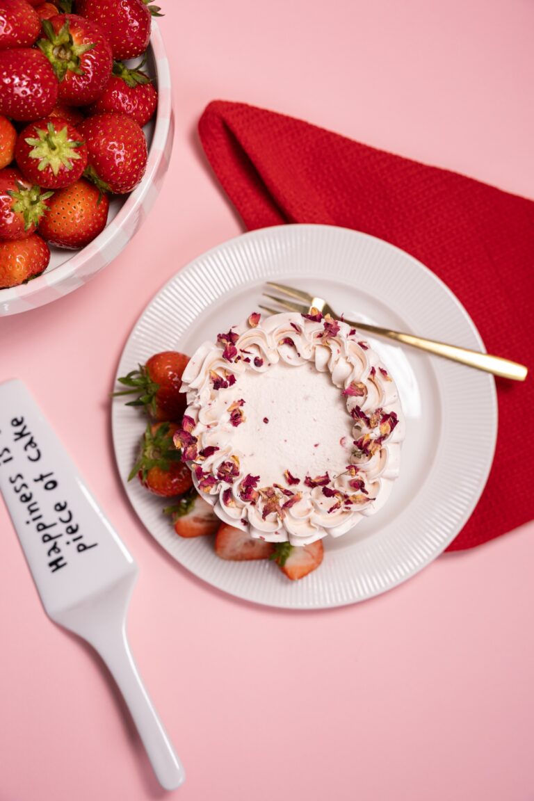 Rose petal cake on a plate with strawberries, seen from above